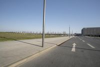 a white truck driving down the highway beside an empty parking lot below an overpass