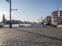 a street view showing the dock and boats in the background with an old fashioned lamp post and tower