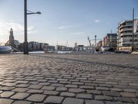 a street view showing the dock and boats in the background with an old fashioned lamp post and tower