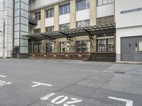 an empty building with signs on the street and people on bikes in traffic passing by