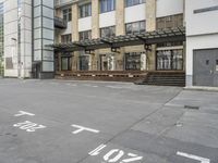 an empty building with signs on the street and people on bikes in traffic passing by