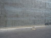 a bench and a cement wall near by the street corner on the sidewalk or on the sidewalk