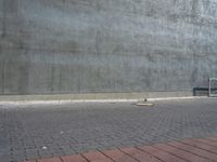 a bench and a cement wall near by the street corner on the sidewalk or on the sidewalk