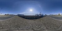 a fish eye view with a large ship in the background and a smaller boat to the right