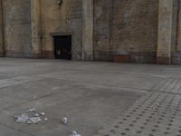 an empty room next to a brick building that is painted yellow and has trash strewn across the floor