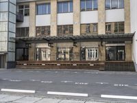 an empty building with signs on the street and people on bikes in traffic passing by