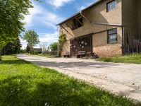 the building has some benches in front of it on the path to the entrance to the house