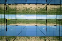 two pictures of a field with a body of water in it and the sky reflected by glass windows