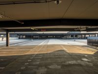 a very large parking garage with lots of lights on the ceiling and some people walking down it