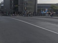 a city street filled with people and traffic next to tall buildings with a metal frame