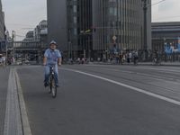 a city street filled with people and traffic next to tall buildings with a metal frame