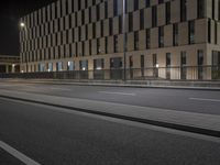 a bus is parked at a curb in a parking lot next to some buildings at night