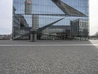 two poles in a city near some buildings and a clock tower in the background is a glass building