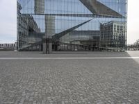 two poles in a city near some buildings and a clock tower in the background is a glass building