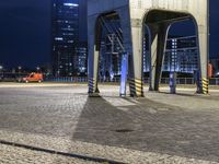 a couple of people that are on a train track by a building at night time