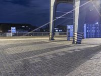 a couple of people that are on a train track by a building at night time