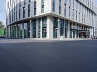 there is a building in the middle of a street with people walking on the street