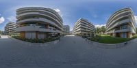 a spherical fish eye photograph of an apartment complex and parking lot, taken from a video camera