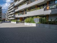 several windows on a building with plants and trees in the courtyard area of this modern apartment complex