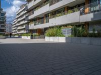 several windows on a building with plants and trees in the courtyard area of this modern apartment complex