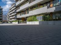 several windows on a building with plants and trees in the courtyard area of this modern apartment complex