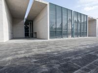 an empty stone floor in front of a building with an open window and some trees