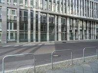 a sidewalk lined with metal steel dividers that create a barrier at the center of a city street