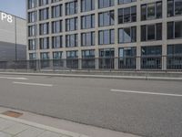 an empty parking lot next to a tall building with multiple stories on the building side