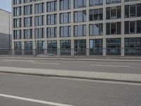 an empty parking lot next to a tall building with multiple stories on the building side
