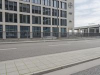 an empty parking lot next to a tall building with multiple stories on the building side