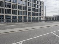an empty parking lot next to a tall building with multiple stories on the building side
