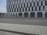an empty parking lot next to a tall building with multiple stories on the building side