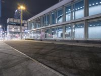 a stop sign that is on the corner of the road at night time near a building