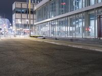 a stop sign that is on the corner of the road at night time near a building