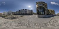 an 360 - view photograph of a very neat building from outside the sphere, on the right is a fountain and stairs