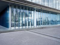 an open glass walkway in front of a building with buildings and lots of windows in the background