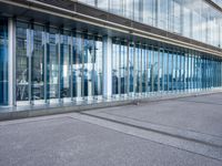 an open glass walkway in front of a building with buildings and lots of windows in the background