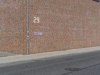 there is a street name plate on the brick building wall of the fire department building