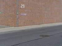 there is a street name plate on the brick building wall of the fire department building