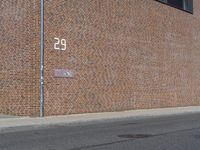 there is a street name plate on the brick building wall of the fire department building