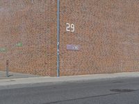 there is a street name plate on the brick building wall of the fire department building