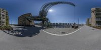 a 360 - ray image of a street intersection with parking lots and a bridge in the background