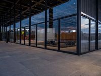 glass walls around the entrance of a modern office building, with a concrete floor underneath the glass wall