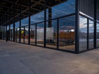 glass walls around the entrance of a modern office building, with a concrete floor underneath the glass wall