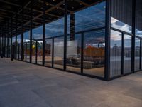 glass walls around the entrance of a modern office building, with a concrete floor underneath the glass wall