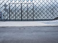 a building with a big metal fence in front of it and one side on the road behind the window