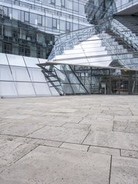 empty walkway with the stairs up to the roof and glass building in background, outdoors