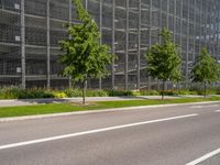 a wide roadway lined with traffic lines and trees on both side of it's driveway