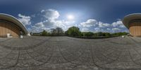 a fish eye lens is in front of some buildings and buildings with blue sky and clouds