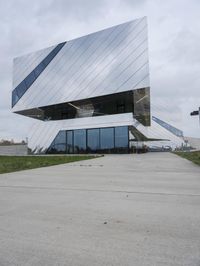 a person is walking on the pavement near the building while wearing a backpack in the air